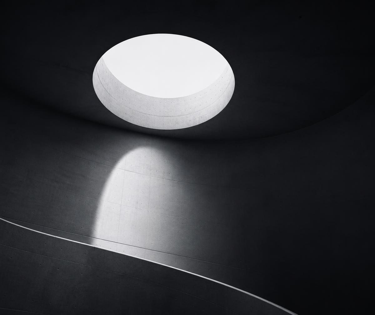 Minimal architectural interior with a circular skylight